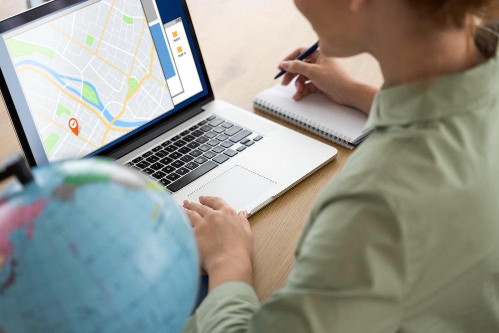 Person planning a delivery route on a laptop with a map interface.